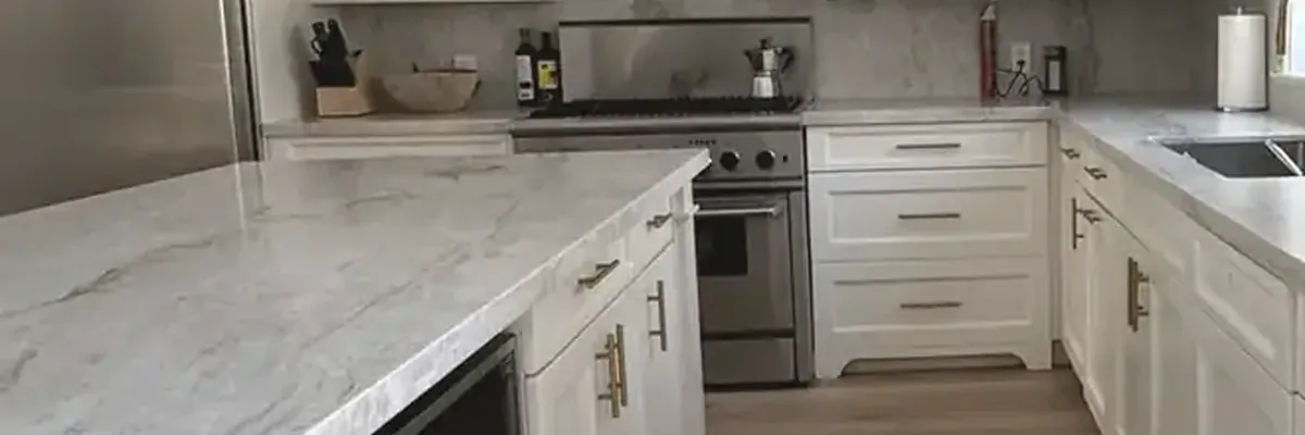 A North York kitchen finished by Co Painting, with a marble island, brass hardware, a stainless range and a wood floor